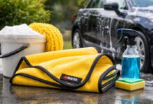 منشفة Mafra Super Dryer لتجفيف السيارة مع أدوات غسيل السيارة الأخرى، مثل دلو الصابون، وقنينة رش، والإسفنجة، في بيئة خارجية