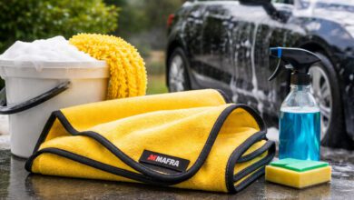 منشفة Mafra Super Dryer لتجفيف السيارة مع أدوات غسيل السيارة الأخرى، مثل دلو الصابون، وقنينة رش، والإسفنجة، في بيئة خارجية