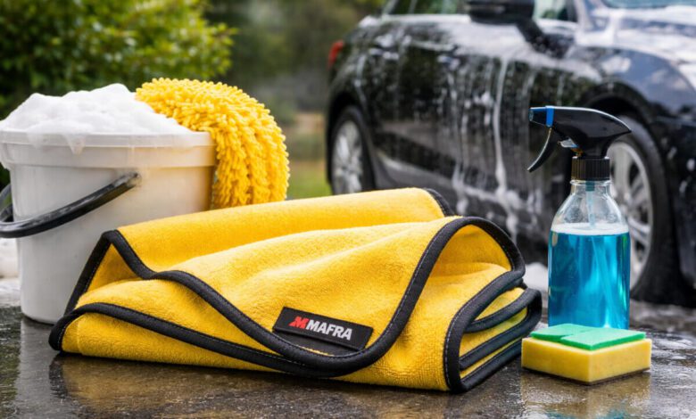 منشفة Mafra Super Dryer لتجفيف السيارة مع أدوات غسيل السيارة الأخرى، مثل دلو الصابون، وقنينة رش، والإسفنجة، في بيئة خارجية