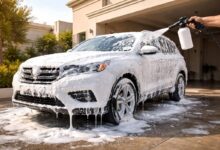 فوم غسيل سيارات كثيف يغطي هيكل سيارة أثناء الغسيل المنزلي أمام منزل في السعودية