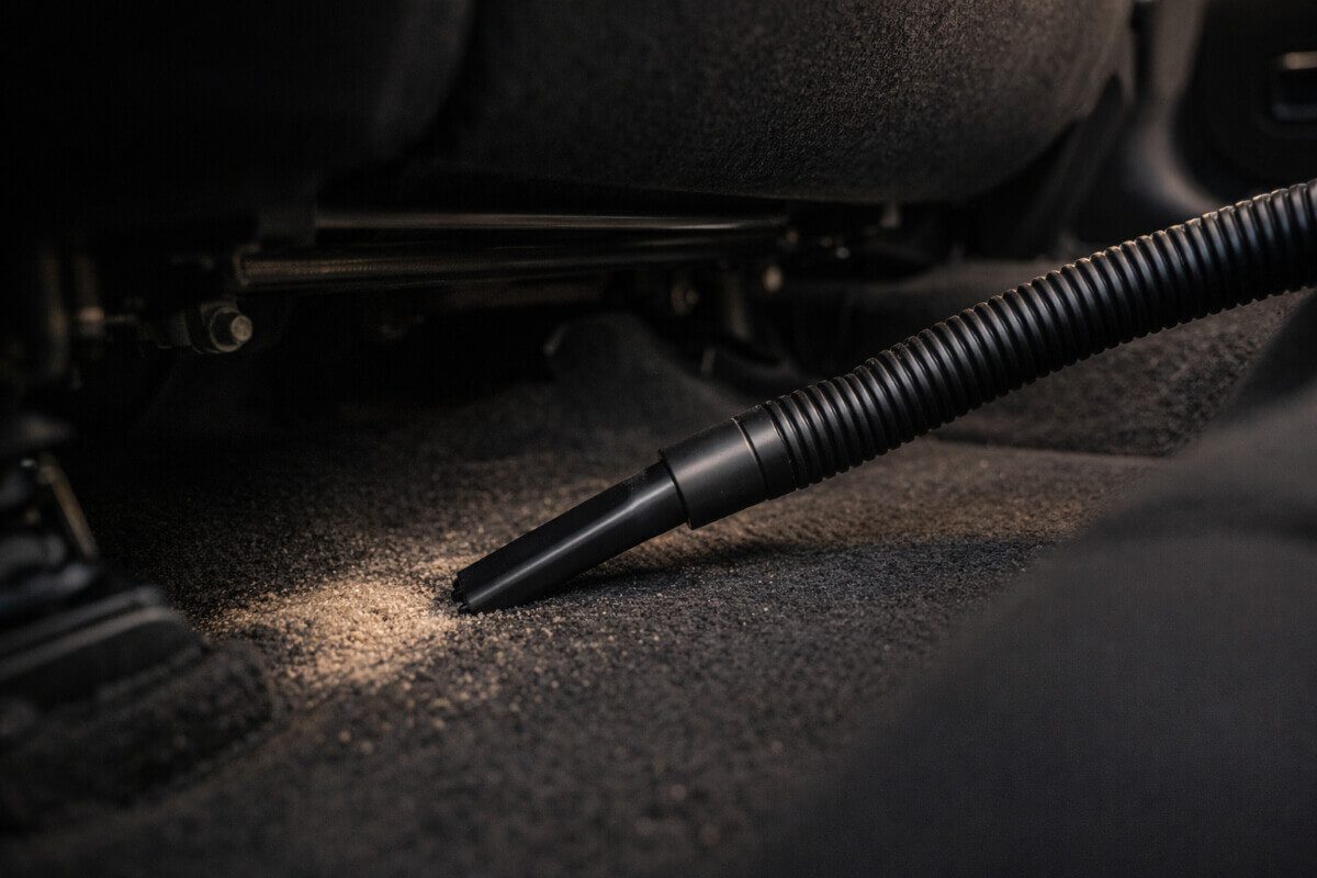 استخدام مكنسة سيارة للوصول أسفل المقاعد والزوايا الضيقة