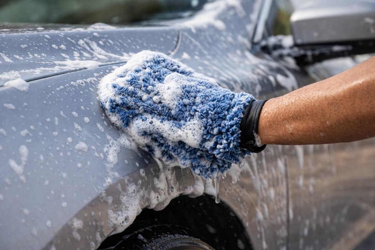 غسيل طلاء السيارة بلطف باستخدام قفاز مايكروفايبر ورغوة شامبو